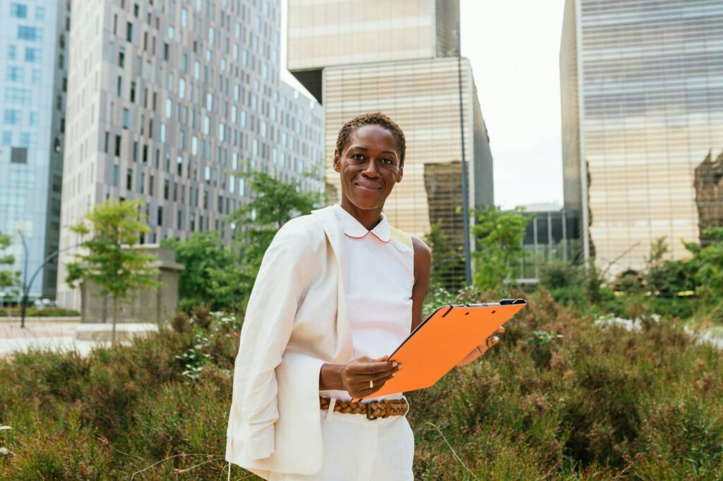 Professional Woman with Clipboard in Urban Green Space